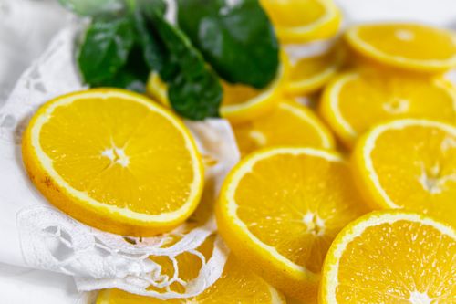 Free Vibrant and fresh orange slices on lace background, perfect for food photography. Stock Photo