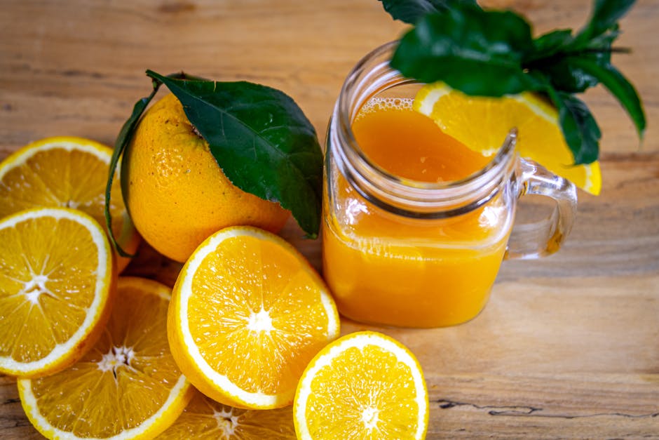 Breville vs Omega: Nutrient Retention Showdown A vibrant close-up of fresh orange juice in a mason jar surrounded by slices and whole oranges.