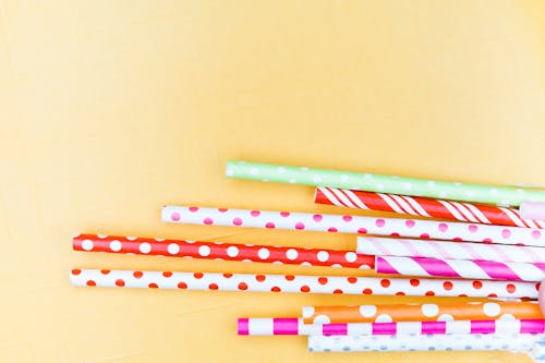 Free Colorful Straws for Drinks on Yellow Background Stock Photo