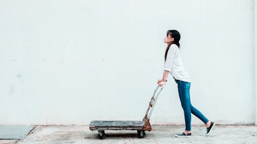 Woman Pushing a Push Cart Dolly 