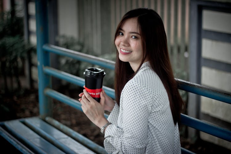 A Woman Holding A Black Tumbler