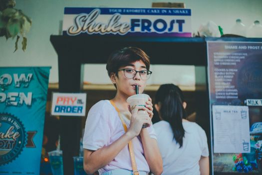 Young woman savoring milkshake at Shake Frost stand in Calabarzon, Philippines.