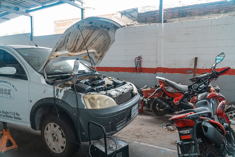 Professional mechanic performing on-site diagnostics with a laptop
