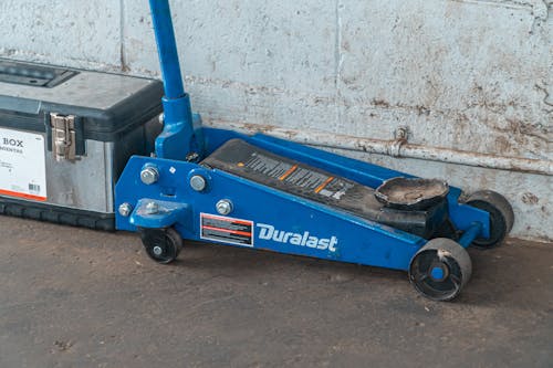 
Blue Tool Jack Lift Car For Repair Beside A Tool Box