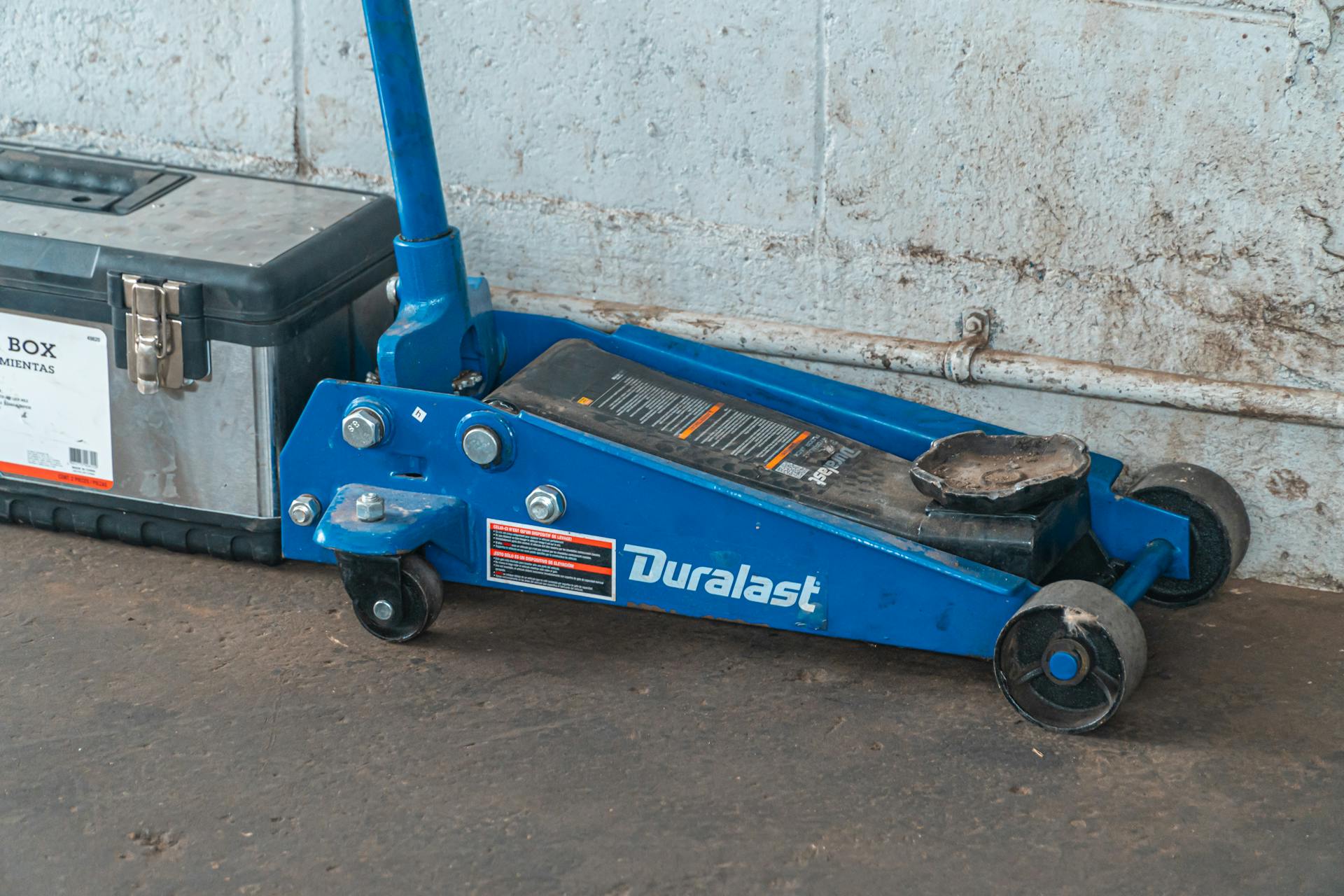 Blue Tool Jack Lift Car For Repair Beside A Tool Box