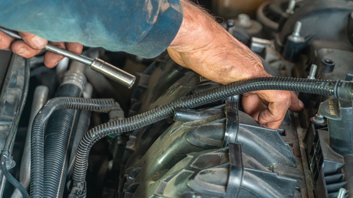 Detailed image of a mechanic repairing a car engine, showcasing technical expertise.