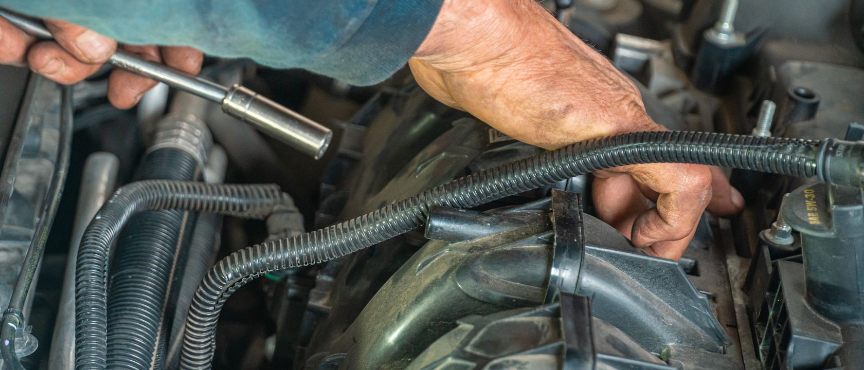 Detailed image of a mechanic repairing a car engine, showcasing technical expertise.