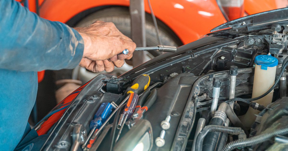 Mechanic carrying out maintenance in a car engine bay