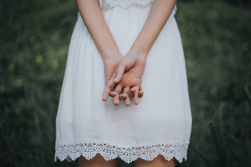 Back View Of Woman in White Dress With Clasped Hands
