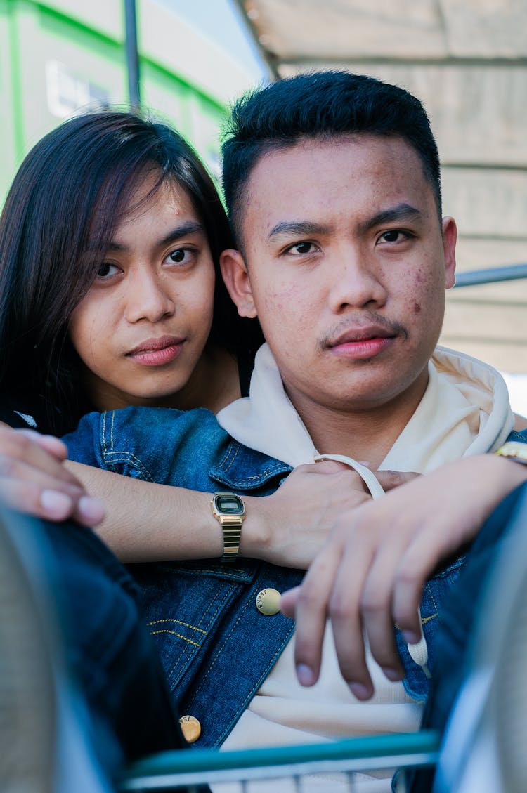 Confident Ethnic Couple In Embrace Looking At Camera