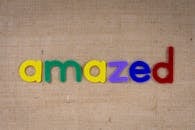 粗麻布表面用五颜六色的塑料字母拼出“惊奇”，创意概念完美