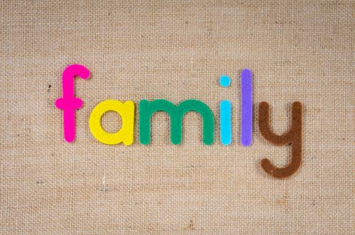 Free Vibrant letters spelling 'family' on a textured burlap background, emphasizing togetherness. Stock Photo