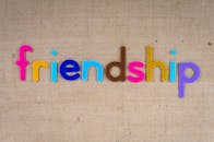 在纹理粗糙的棕色麻布背景上，充满活力的字母拼写出“友谊”二字