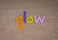 在纹理织物背景上，彩色毛毡字母拼出“发光”二字