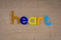 彩色字母在粗麻布纹理背景上拼出“心脏”，非常适合创意项目