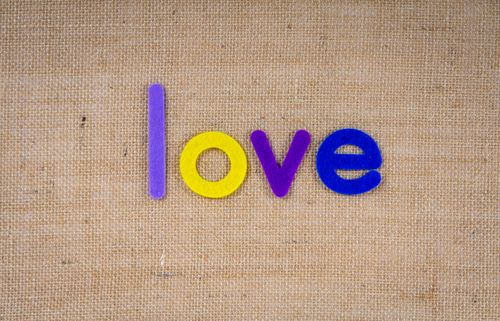 Free Close-up of colorful felt letters spelling 'love' on a burlap texture. Perfect for romantic and creative designs. Stock Photo