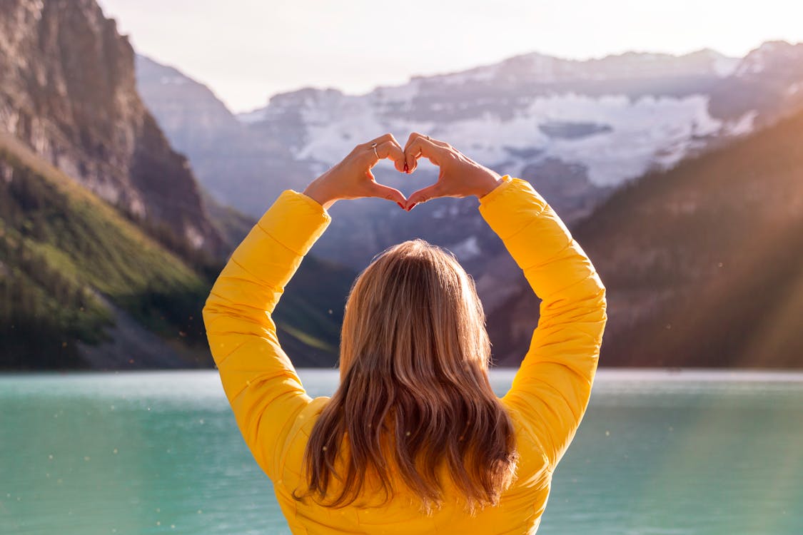 woman making heart sign on holiday.