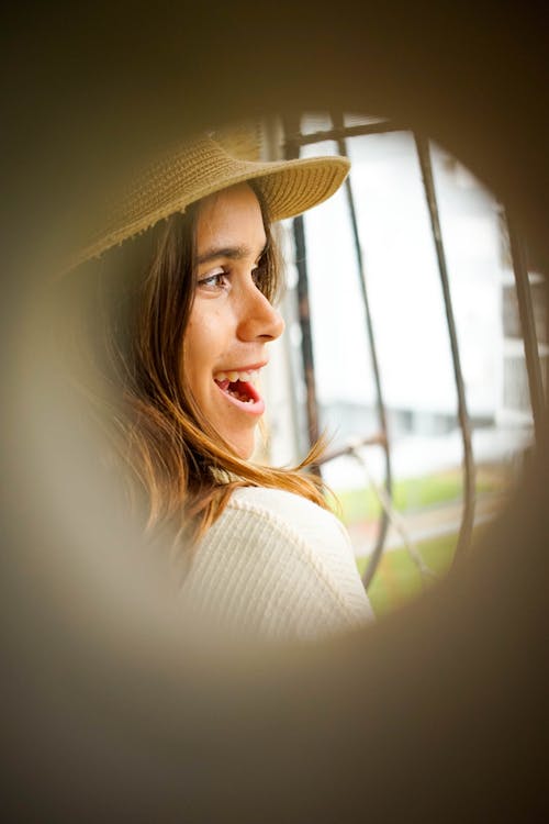 Woman in White Long Sleeve Shirt Wearing Brown Straw Hat