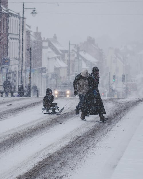 People Crossing A Snow Covered Street