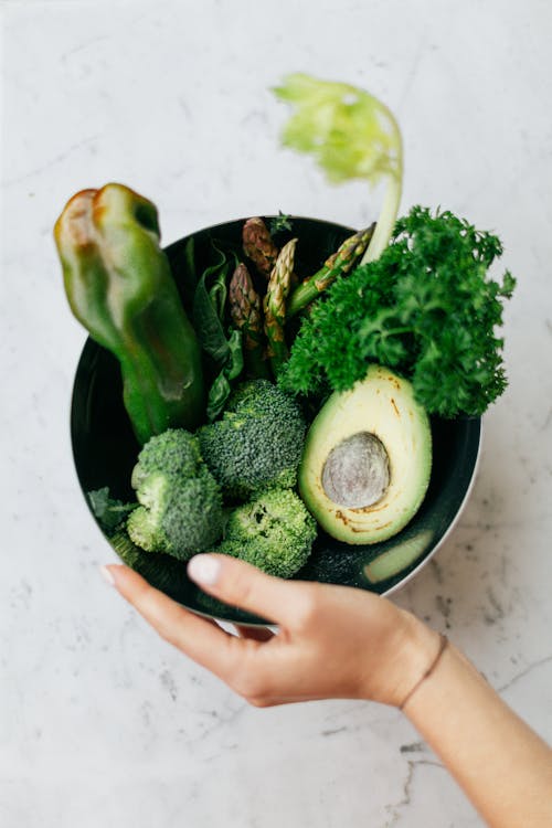 Free Photo Of Female Hand Holding A Bowl Of Green Vegetables  Stock Photo