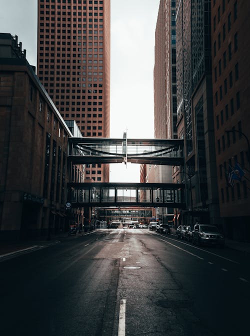 Cars Parked on Side of the Road in Between High Rise Buildings