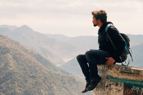 Risky traveler on stone above valley