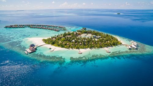 Free Stunning aerial shot of a Maldives island resort surrounded by turquoise waters. Stock Photo