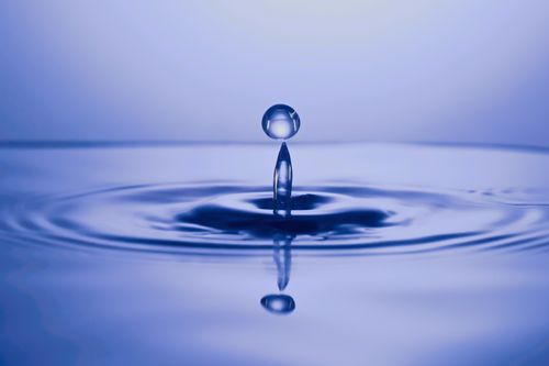Free Closeup of transparent water drop falling and leaving circles on surface in dark water Stock Photo