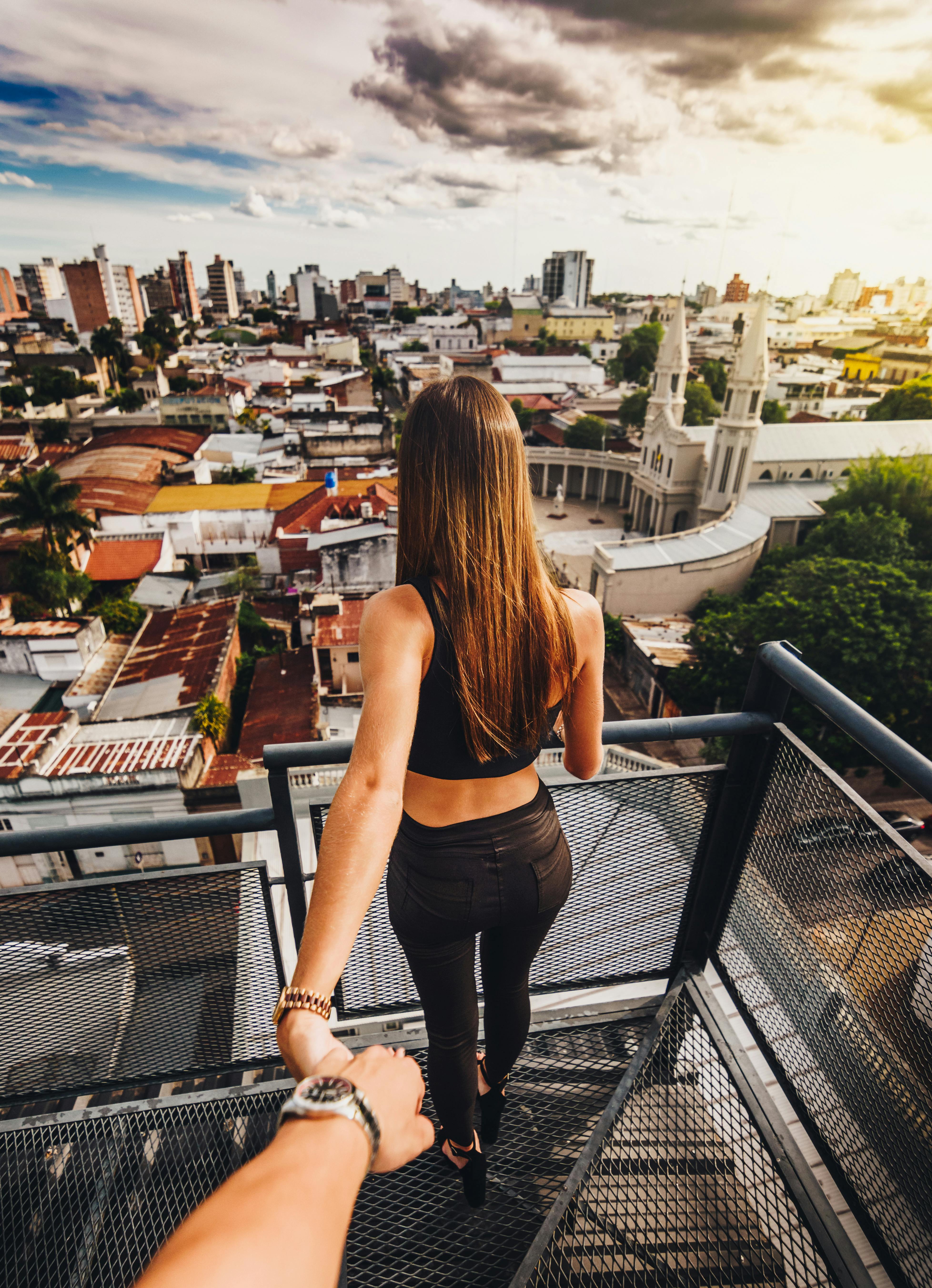 woman in black tank top and black denim jeans standing on balcony