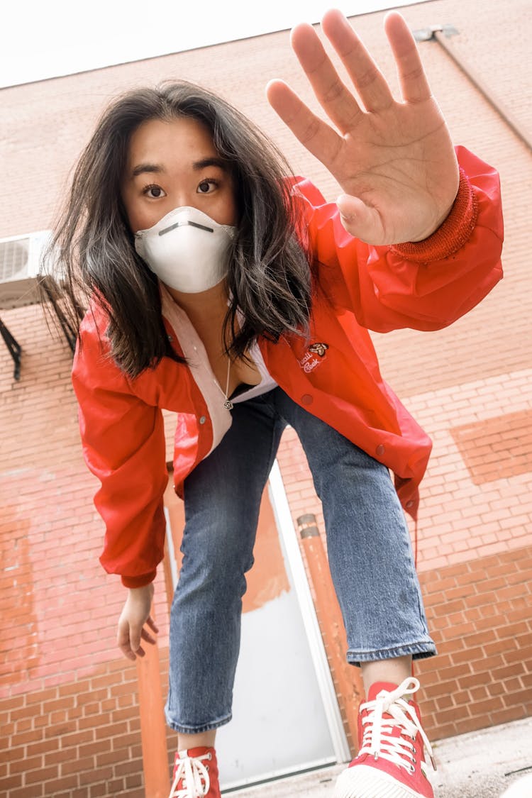 Ethnic Woman In Respirator Saying Hello During COVID 19 Pandemic