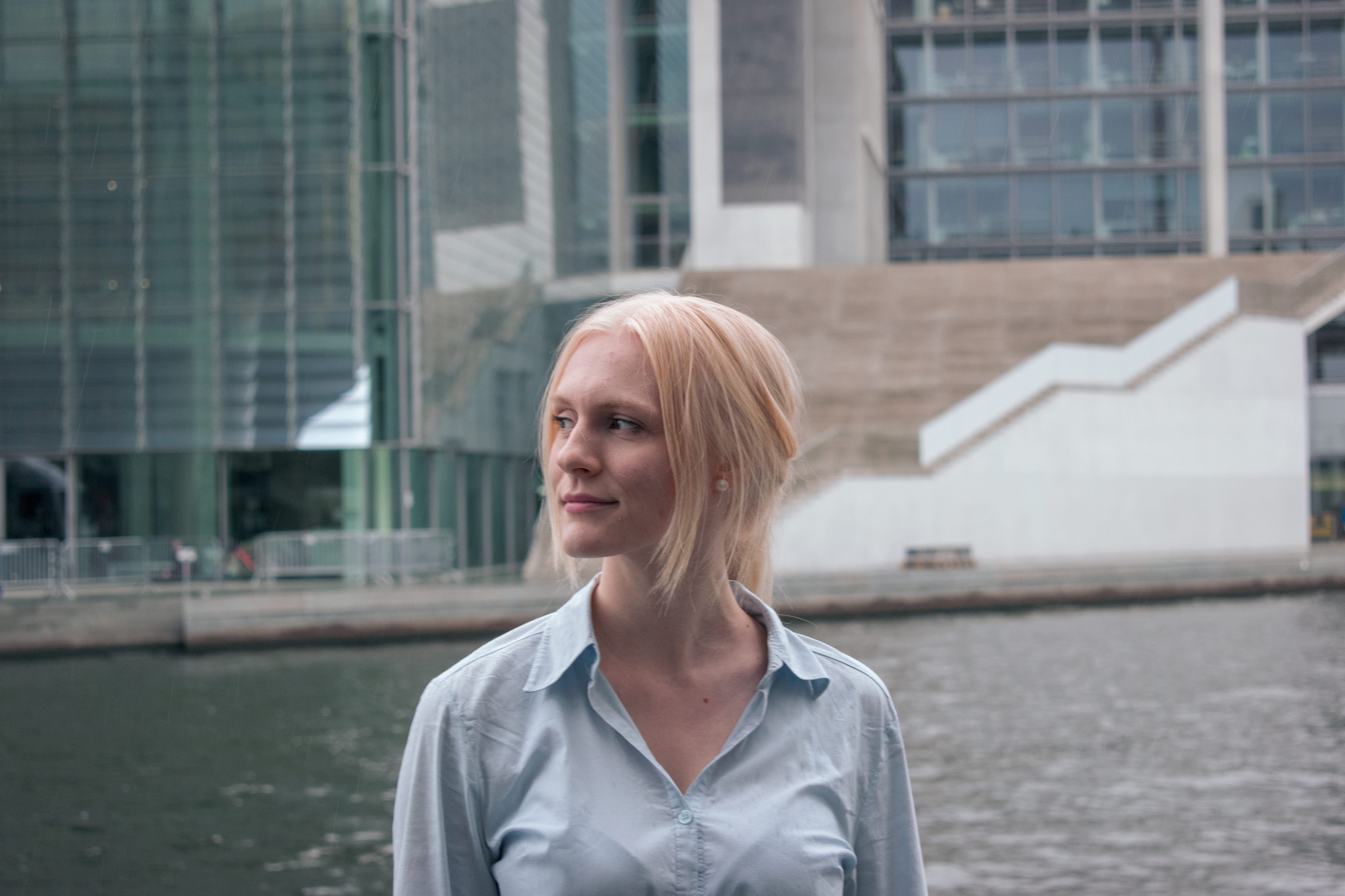 Blonde woman standing outside by modern architectural structures