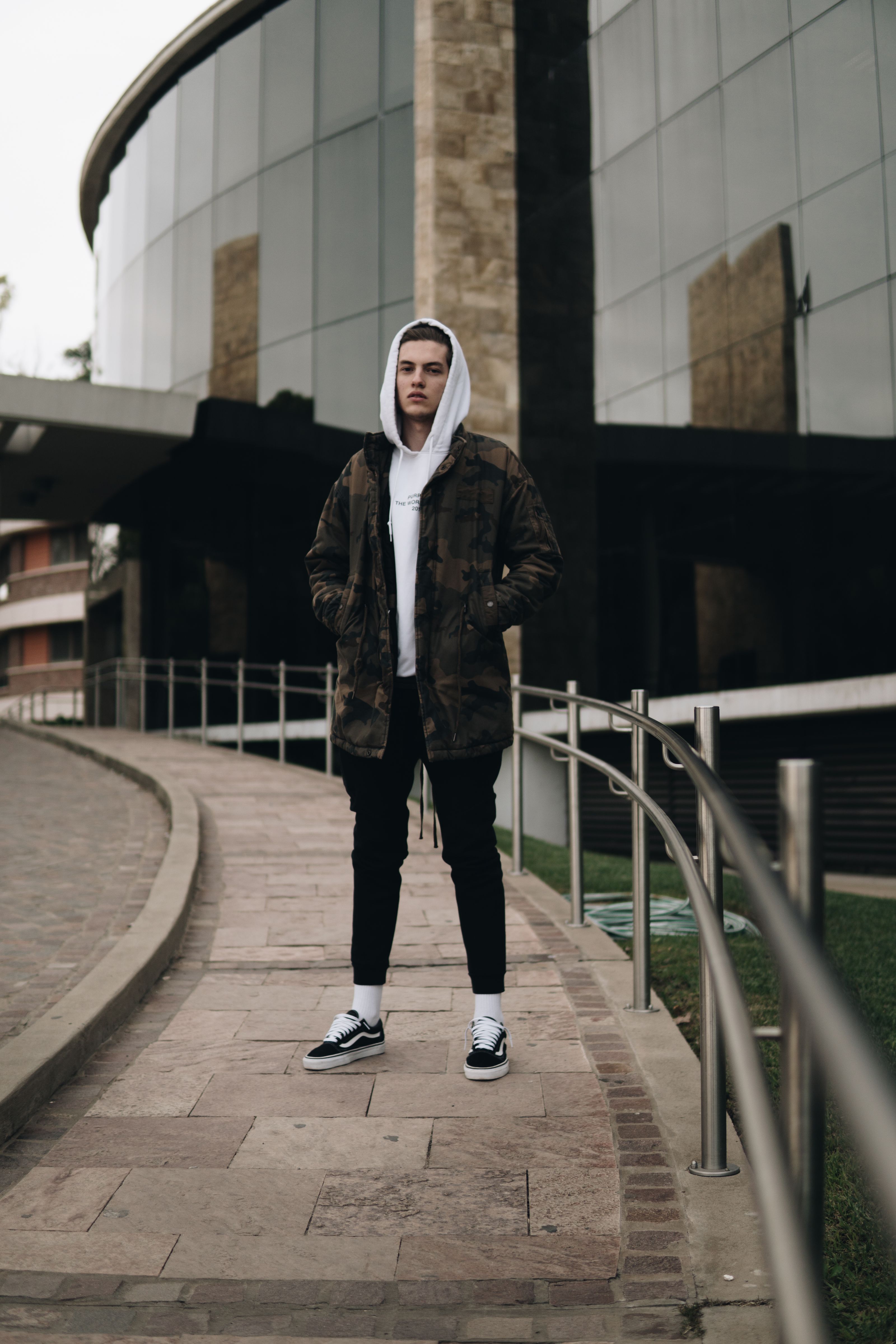 Moda urbana trendy com um jovem adulto masculino usando hoodie e casaco.