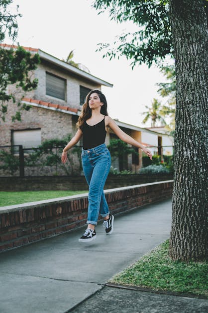 Woman wearing black V-neck sleeveless top and distressed blue denim pants  outfit while taking photo photo – Free Female Image on Unsplash