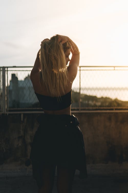 Woman in Black Shirt Standing Near Fence