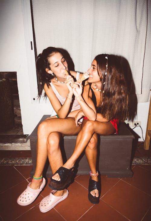 2 Women Sitting on Black Wooden Table