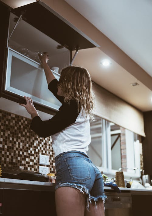 Woman in Black Long Sleeve Shirt and Blue Denim Jeans Raising Her Hands