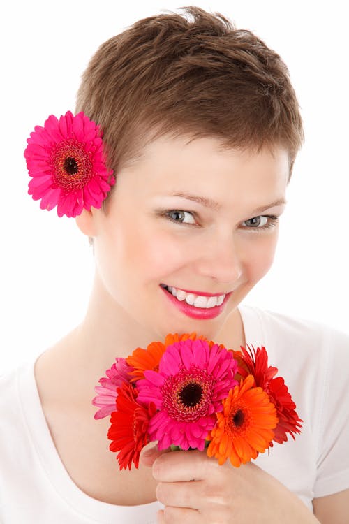 Free Woman Holding Flowers While Smiling Stock Photo