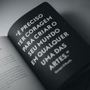 From above black and white of open textbook with creative design and quote on page creating contrast on table in flat