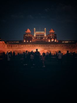 一群游客欣赏着新德里红堡灯火通明的迷人夜景