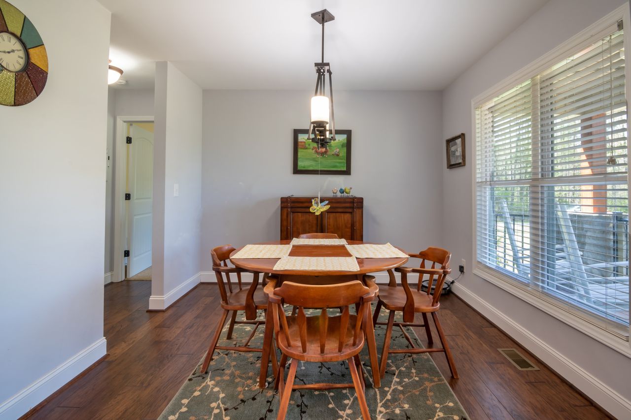 Wooden table with four chairs in a bright breakfast nook by windows