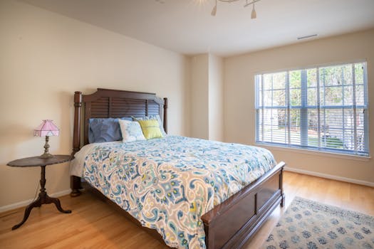 A spacious bedroom featuring a wooden bed, elegant bedding, and a serene atmosphere.