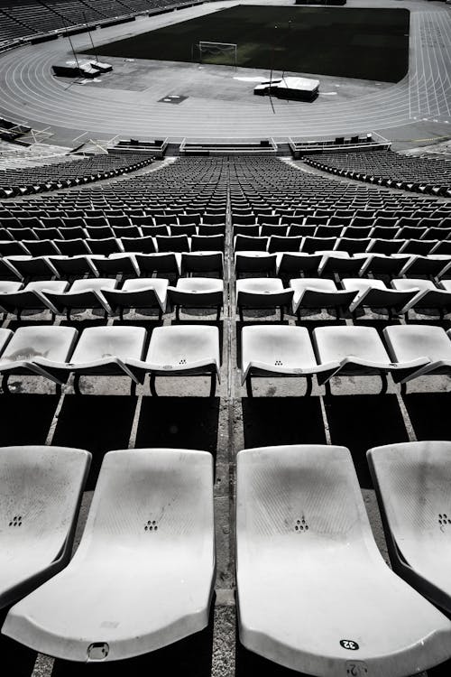 High angle black and white runner stadium empty seat rows above race tracks