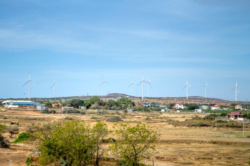 Free Wind turbines standing tall in a rural landscape with a clear sky, highlighting renewable energy. Stock Photo