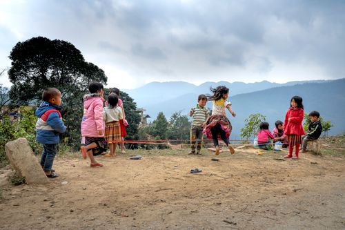 Free Group of children enjoying a playful day outside in a rural mountain landscape. Stock Photo