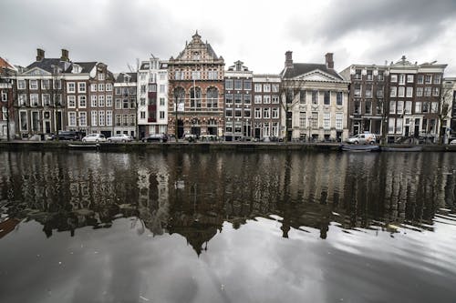 Free Old city street near canal on overcast day in Amsterdam Stock Photo