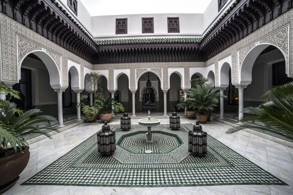 Cour intérieure d'un palais oriental ornée de mosaïques, d'arches et d'une fontaine