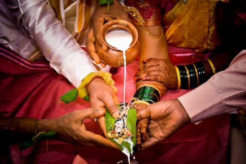 Crop newlywed Indian couple during traditional wedding ritual