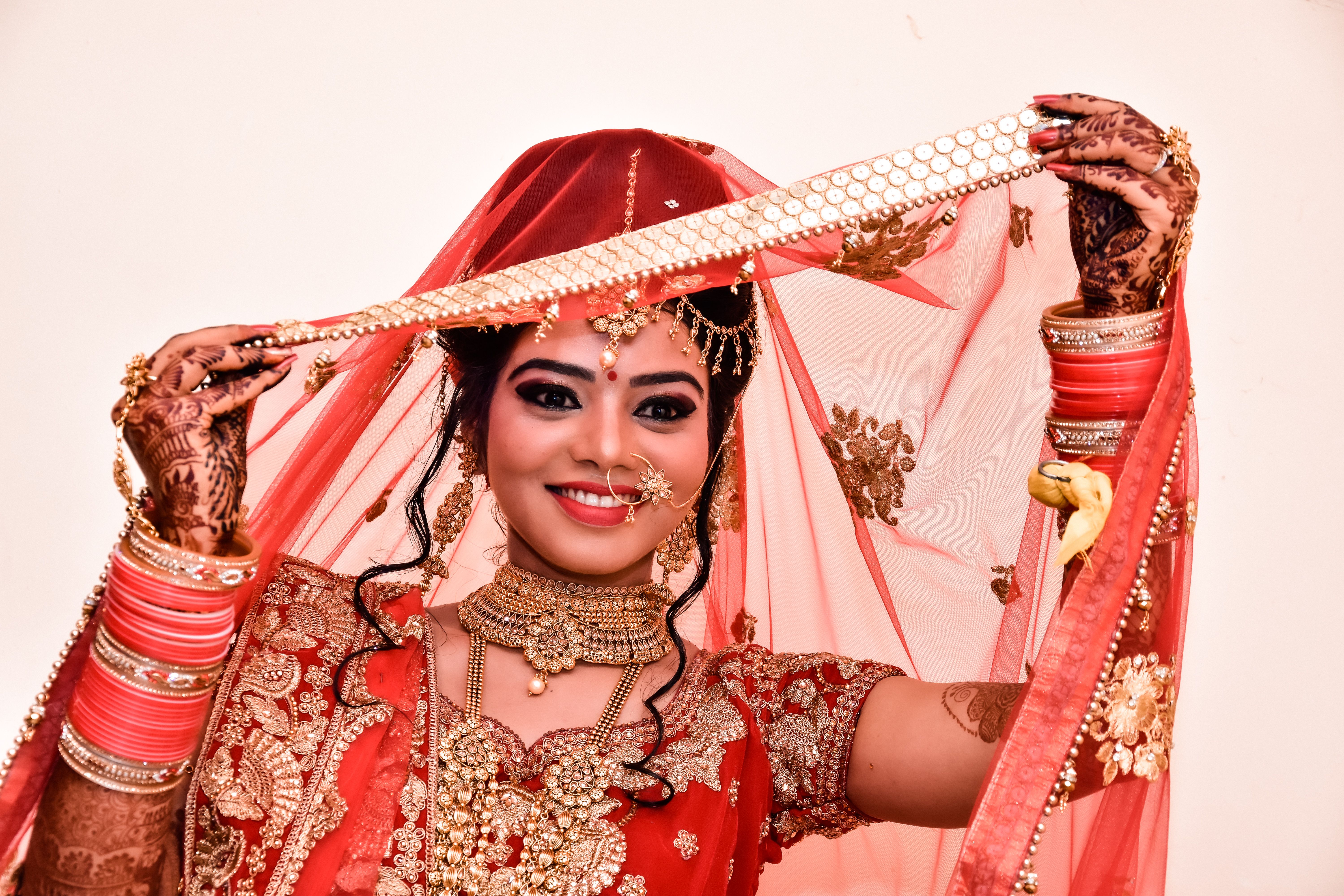 Captivating Indian bride in red traditional bridal wear, smiling with elegance.