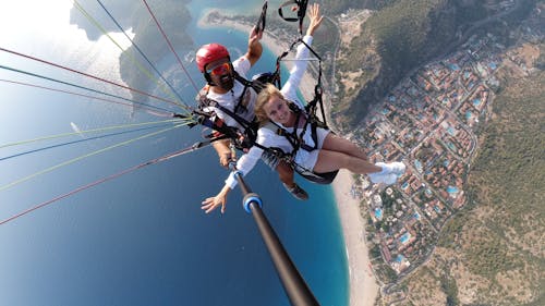 A Man and a Woman Taking a Selfie While Paragliding