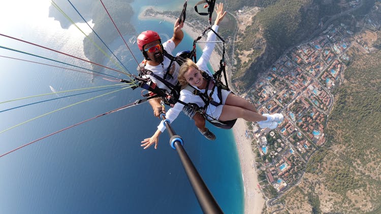 A Man And A Woman Taking A Selfie While Paragliding